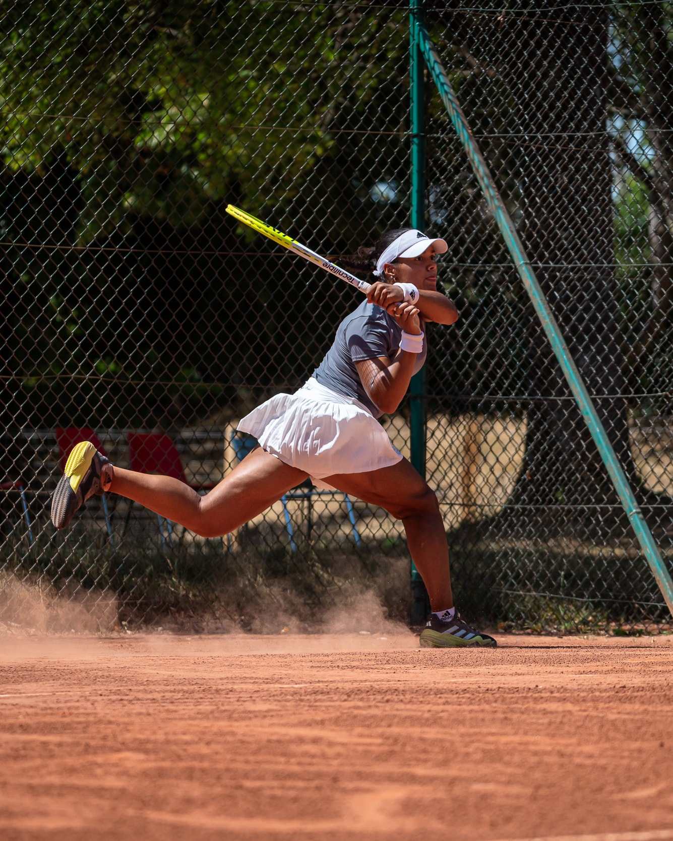 Jade sliding on clay, fully stretched on a forehand