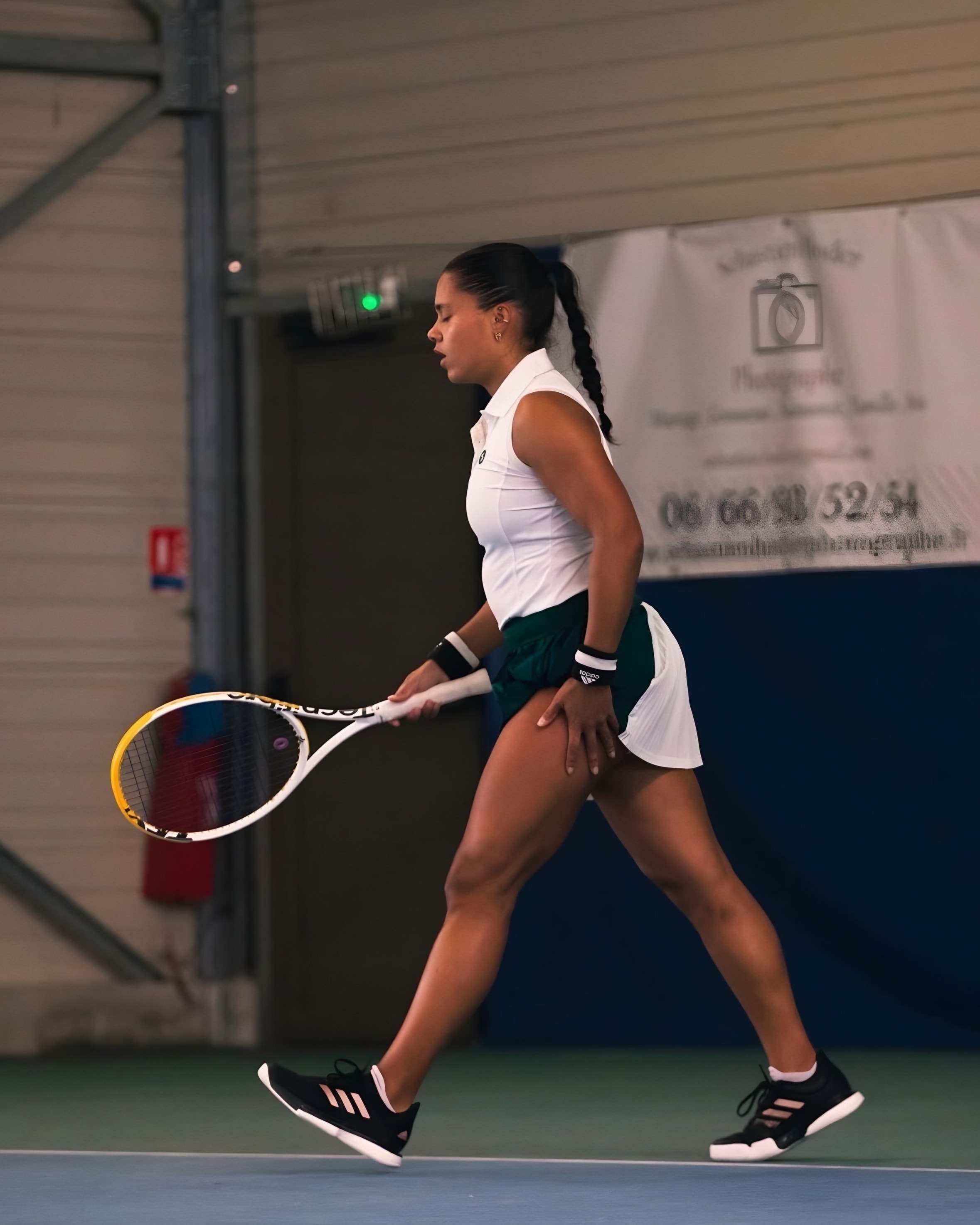 Jade between points on an indoor court, hand resting on her thigh